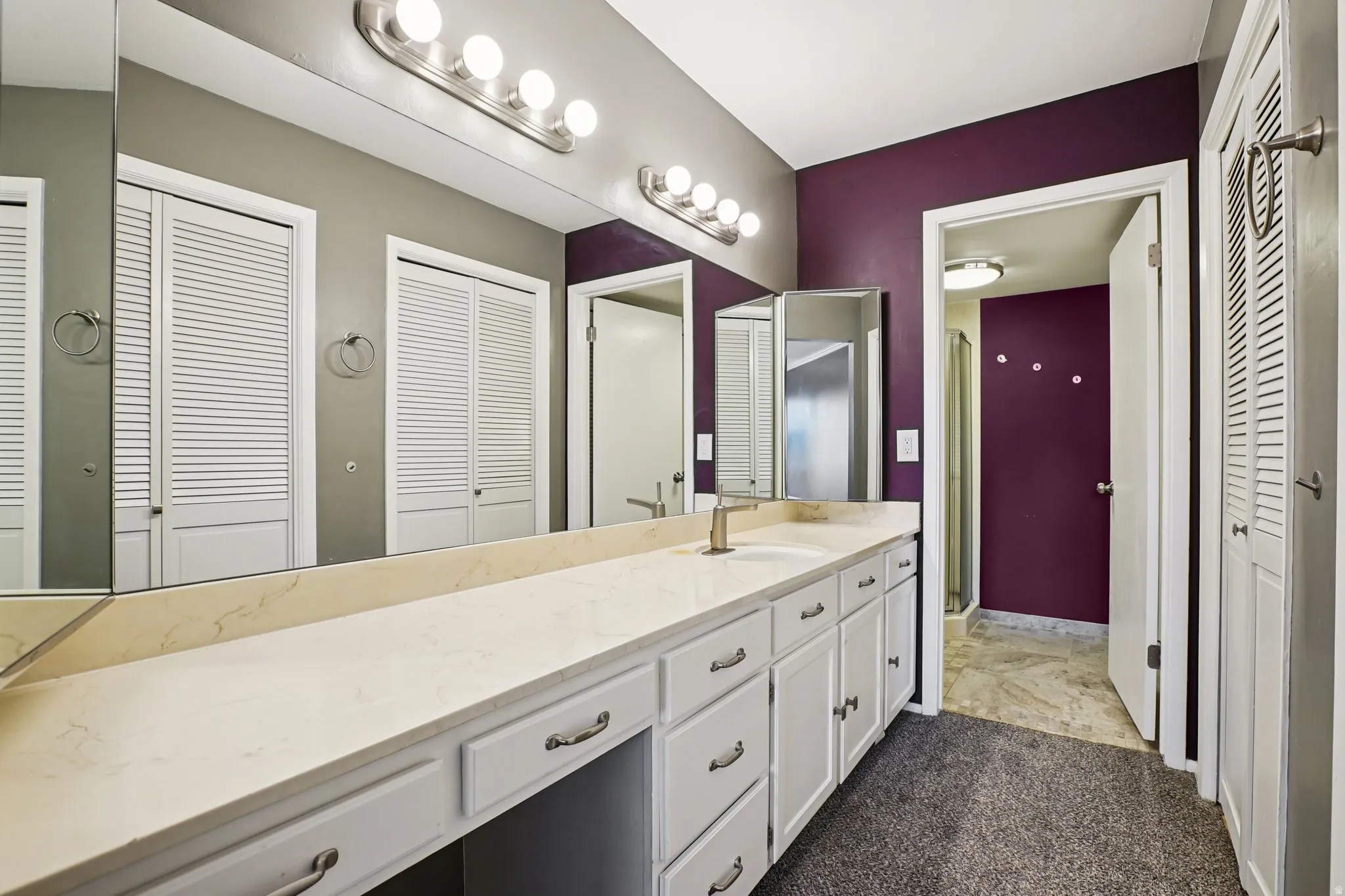 Bathroom with a closet, a stall shower, and vanity