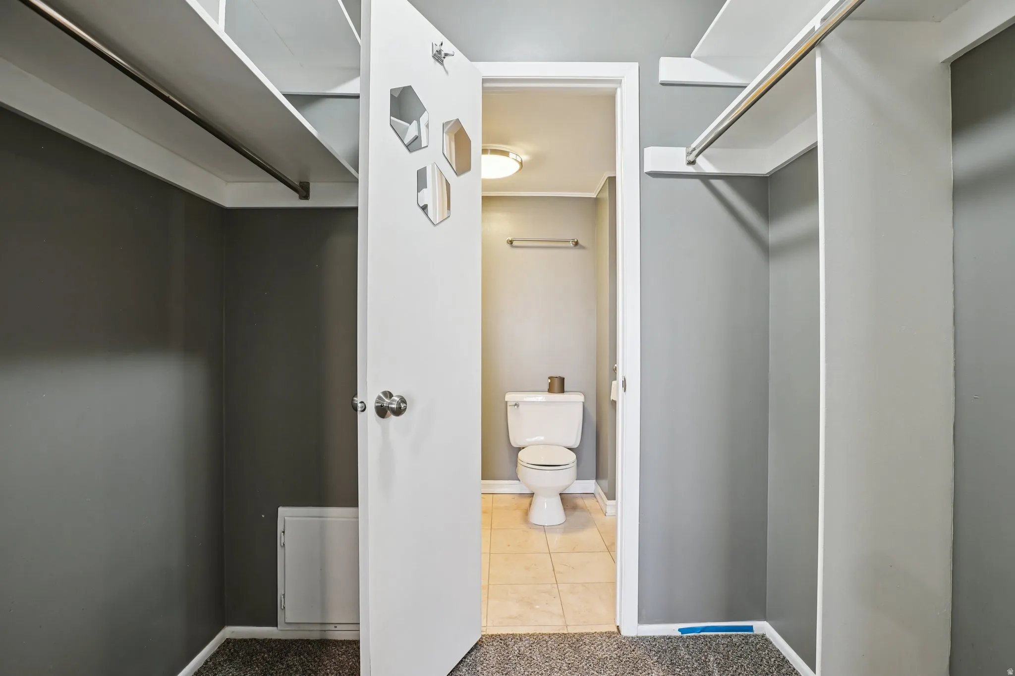 Walk in closet with carpet floors and tile patterned floors