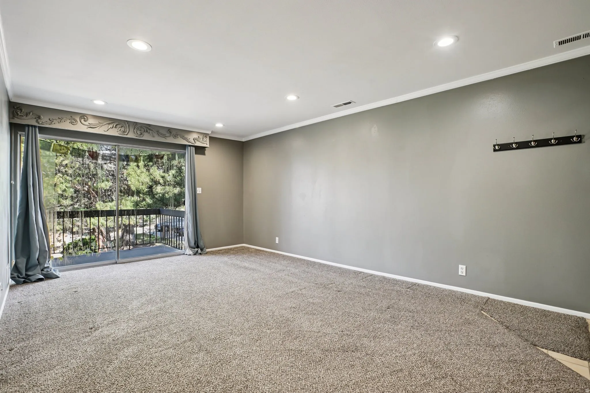 Spare room featuring ornamental molding, carpet flooring, and recessed lighting