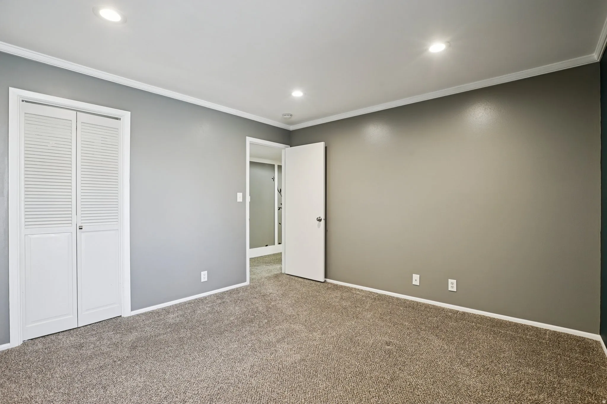 Unfurnished bedroom featuring crown molding, carpet, a closet, and recessed lighting