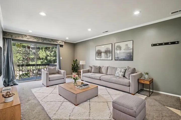 Carpeted living area featuring ornamental molding and recessed lighting