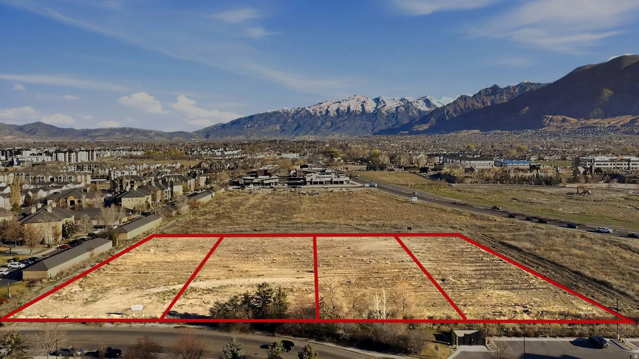Aerial perspective of suburban area with property boundaries highlighted and a mountain backdrop. Facing North
