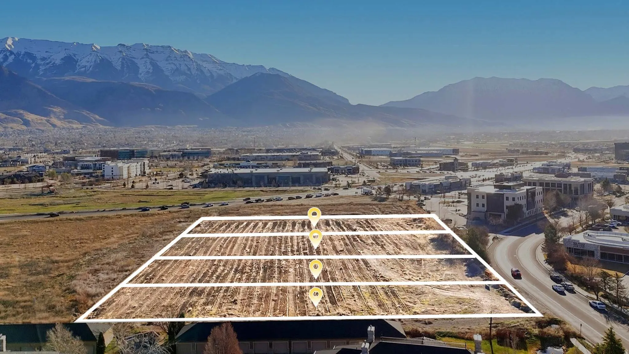Aerial view of property and surrounding area featuring a mountain backdrop and property boundaries highlighted