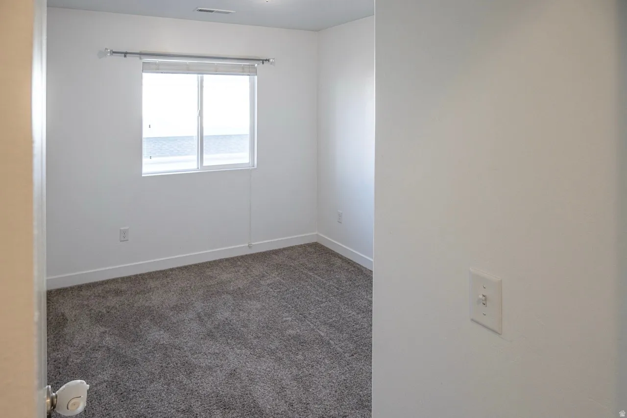 Empty room with carpet and baseboards