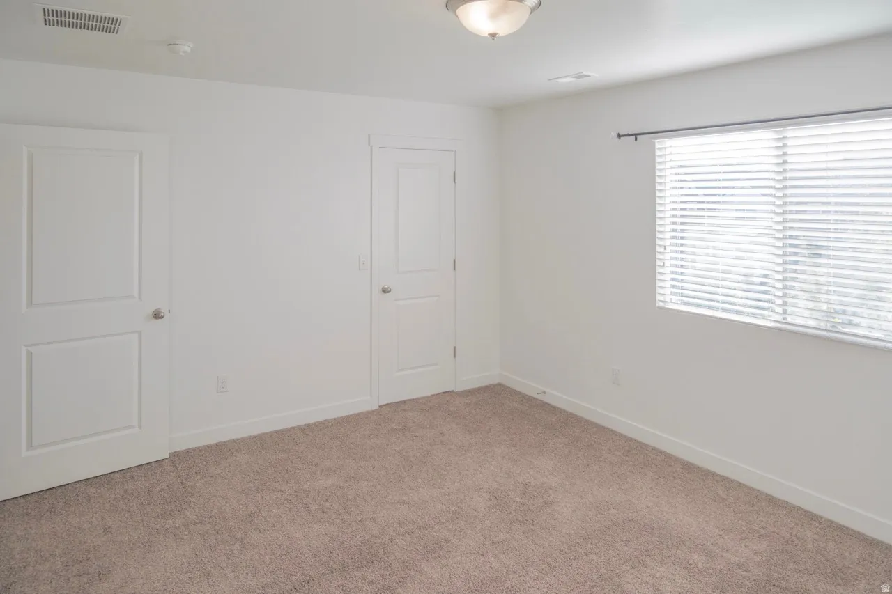 Unfurnished bedroom with carpet flooring and baseboards