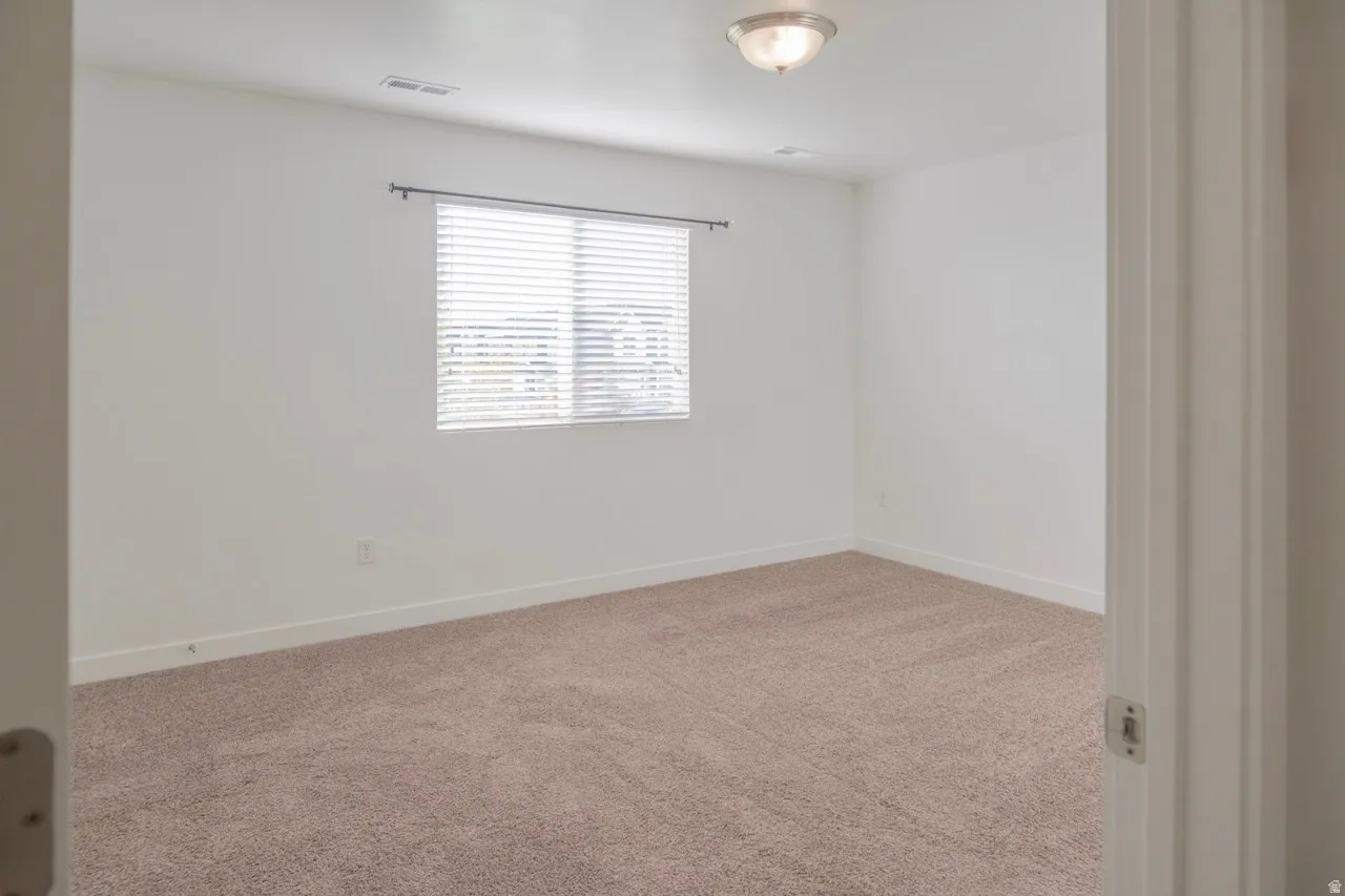 Carpeted empty room featuring baseboards