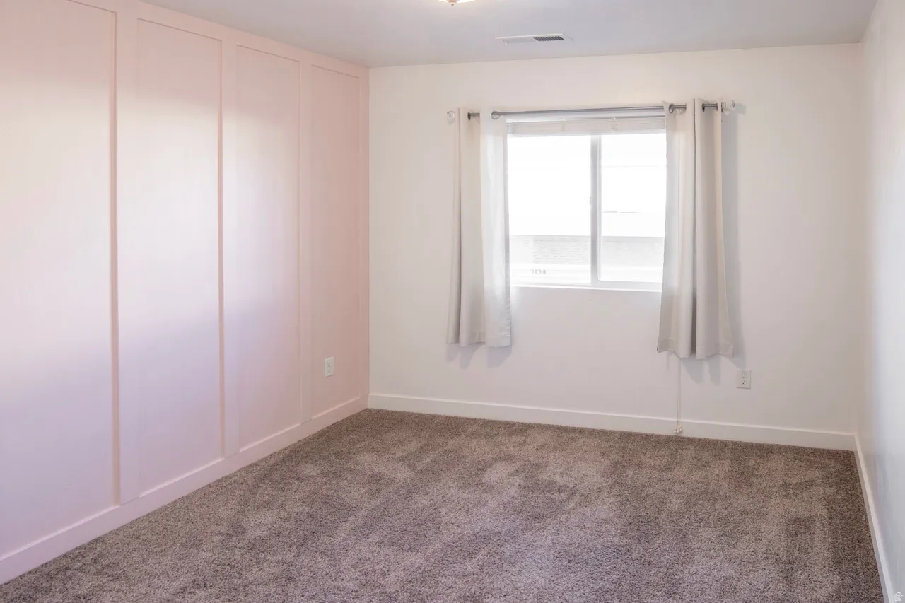 Empty room with carpet flooring and a decorative wall