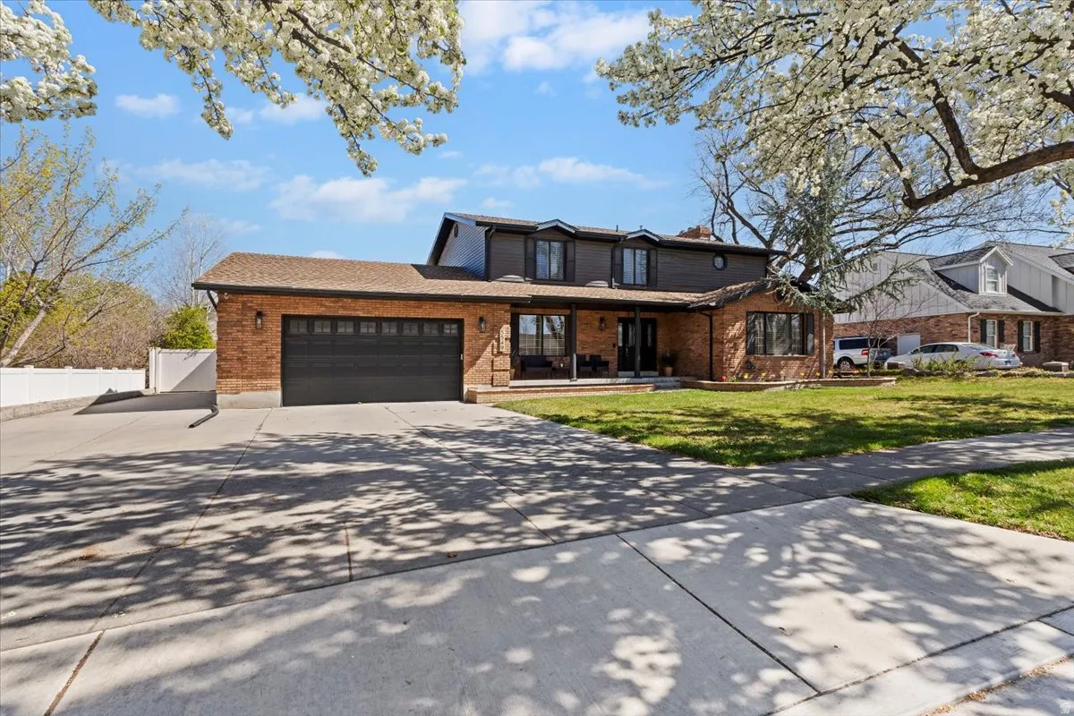 Traditional-style house featuring a porch, concrete driveway, a garage, and brick siding