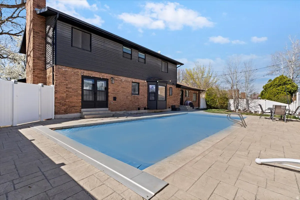 View of swimming pool featuring entry steps, patio surround, and french doors