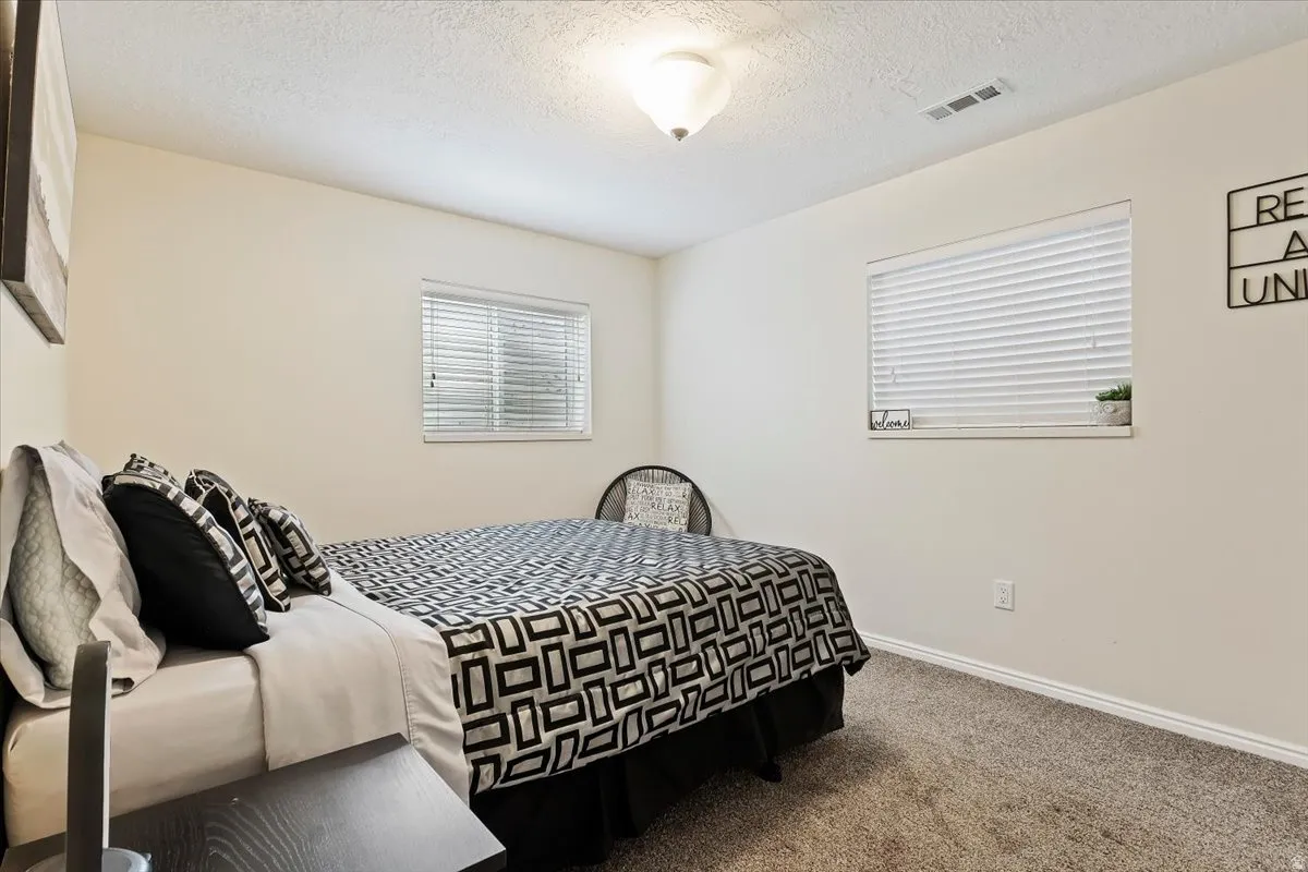 Bedroom with carpet floors and a textured ceiling