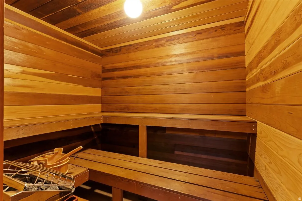 Relaxing sauna featuring wooden walls and wooden ceiling
