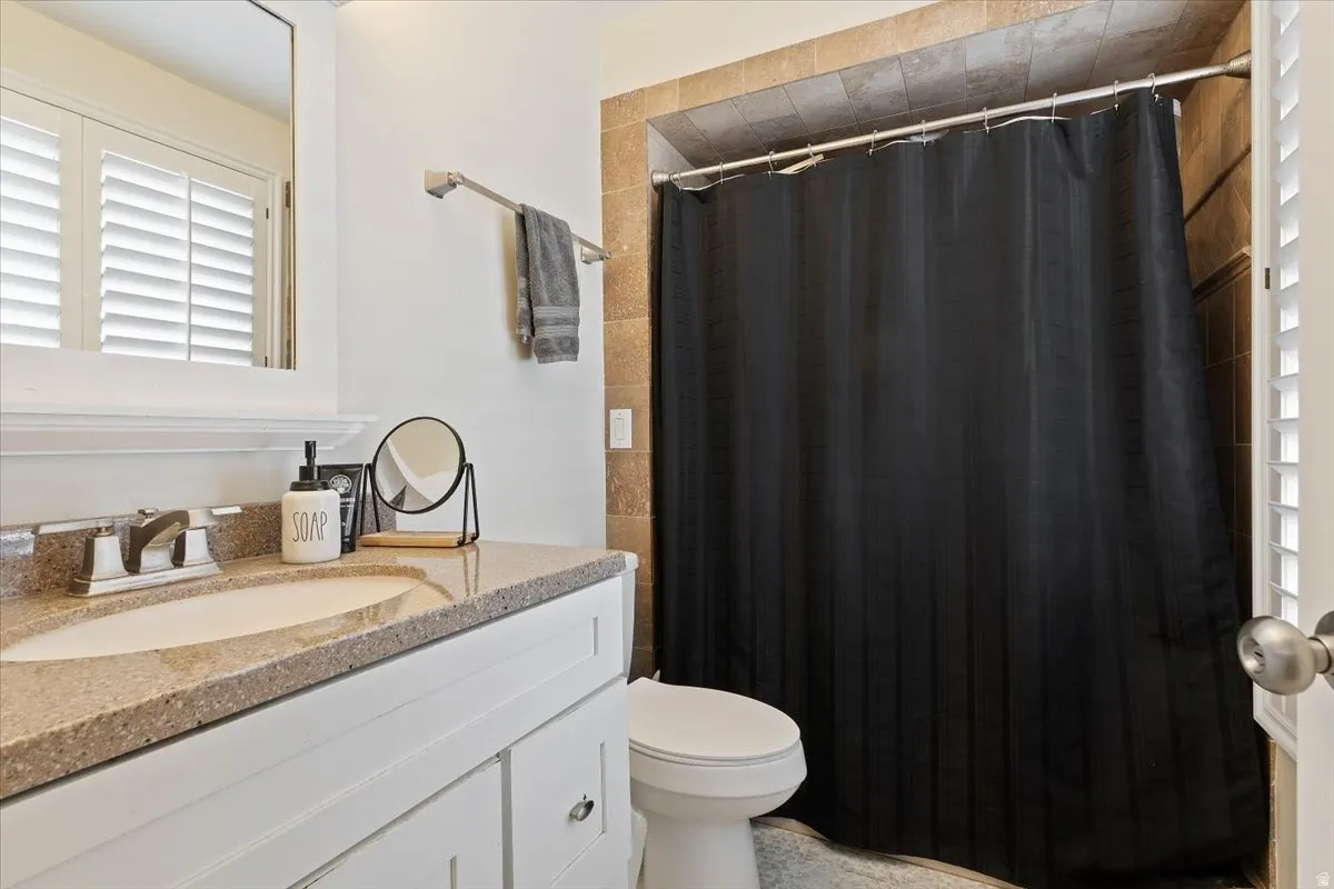 Bathroom with a shower with curtain and vanity