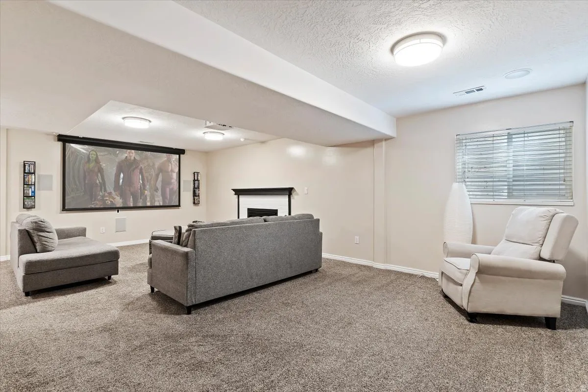 Carpeted living area with a fireplace and a textured ceiling
