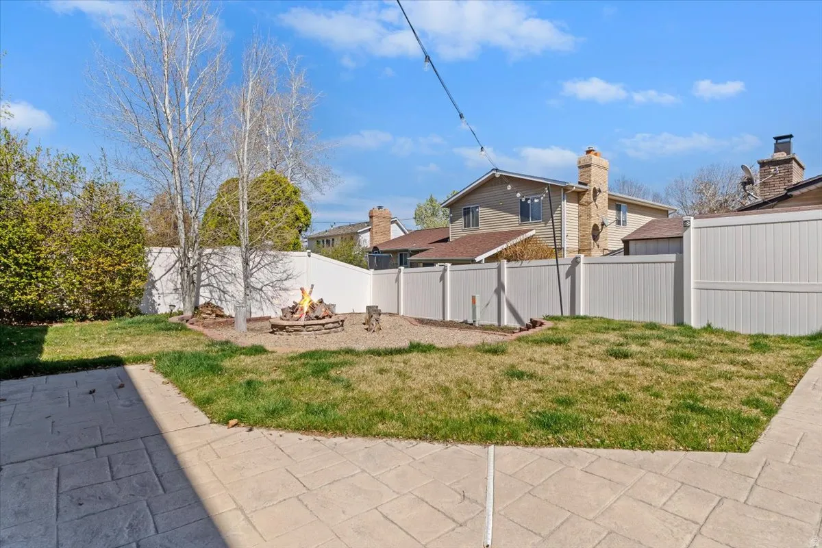 Fenced backyard featuring a fire pit