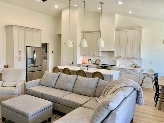 Living room with light wood-style flooring and a high textured ceiling