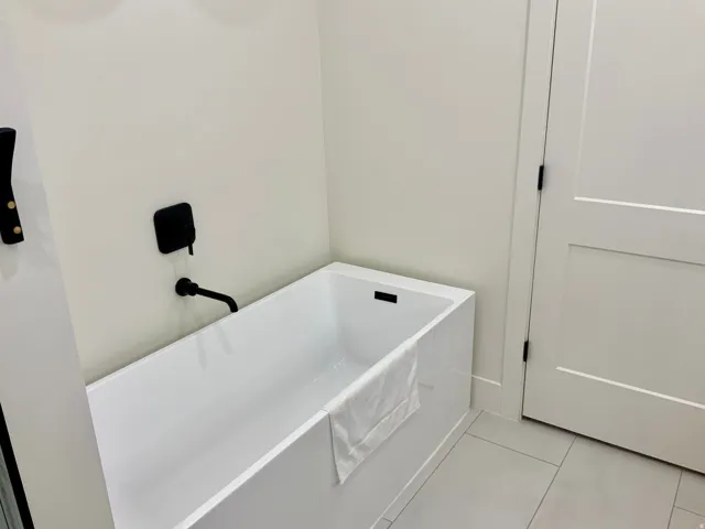 Full bathroom with light tile patterned flooring and a soaking tub