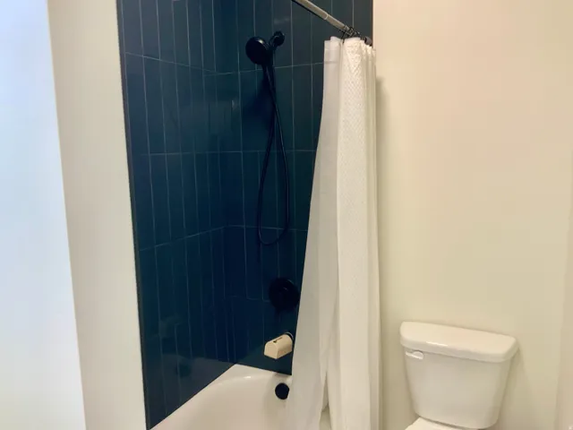 Bathroom featuring toilet and shower / bath combo