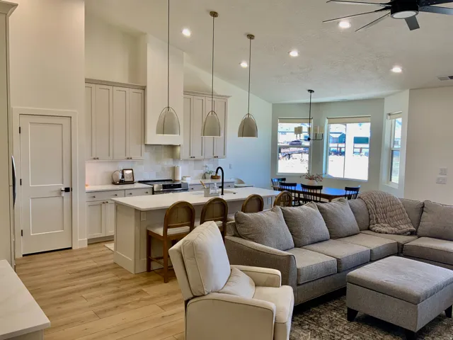 Living area with lofted ceiling, light wood-style floors, ceiling fan, and recessed lighting