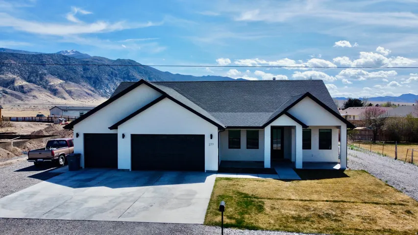 Modern farmhouse style home with a mountain view, a shingled roof, a garage, and driveway