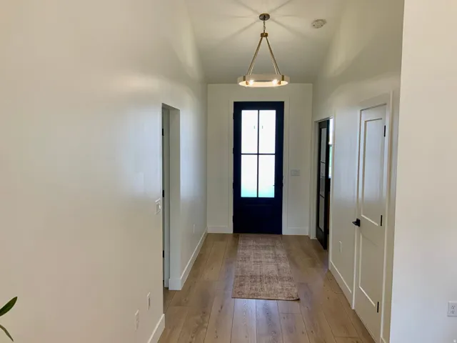 Foyer entrance featuring light wood-type flooring and vaulted ceiling