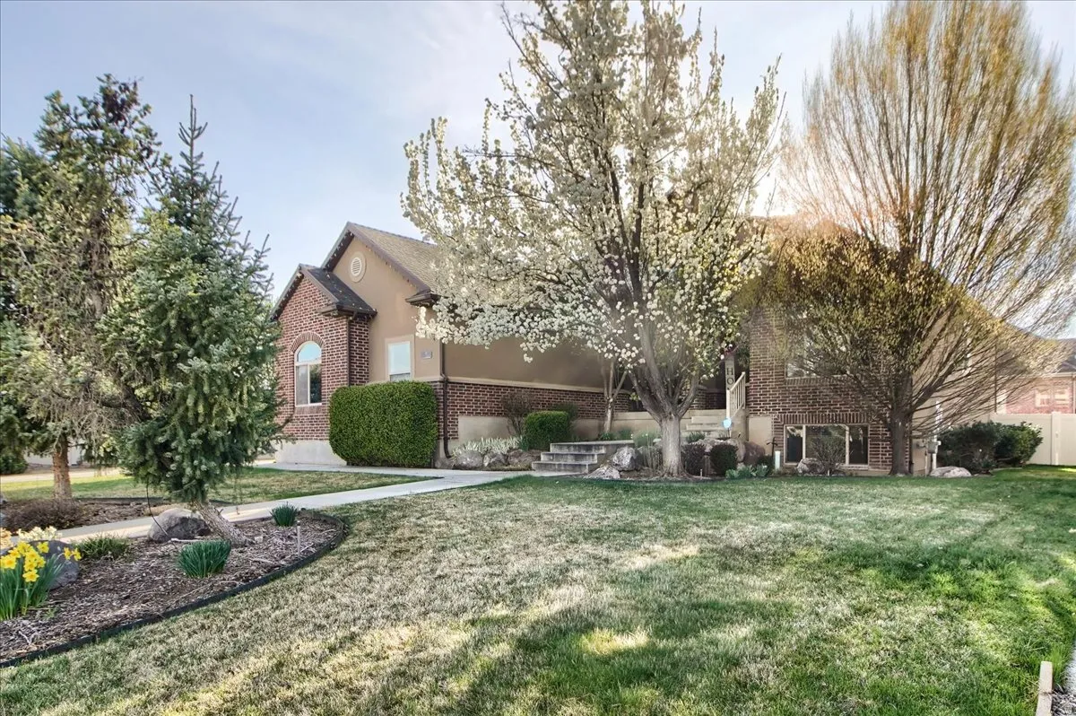 Obstructed view of property featuring brick siding and a front lawn