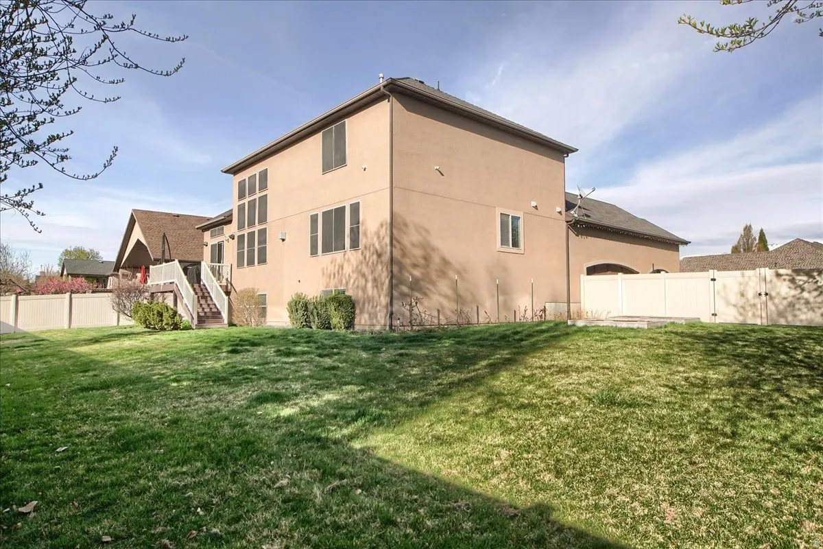 Back of house with a fenced backyard and stucco siding