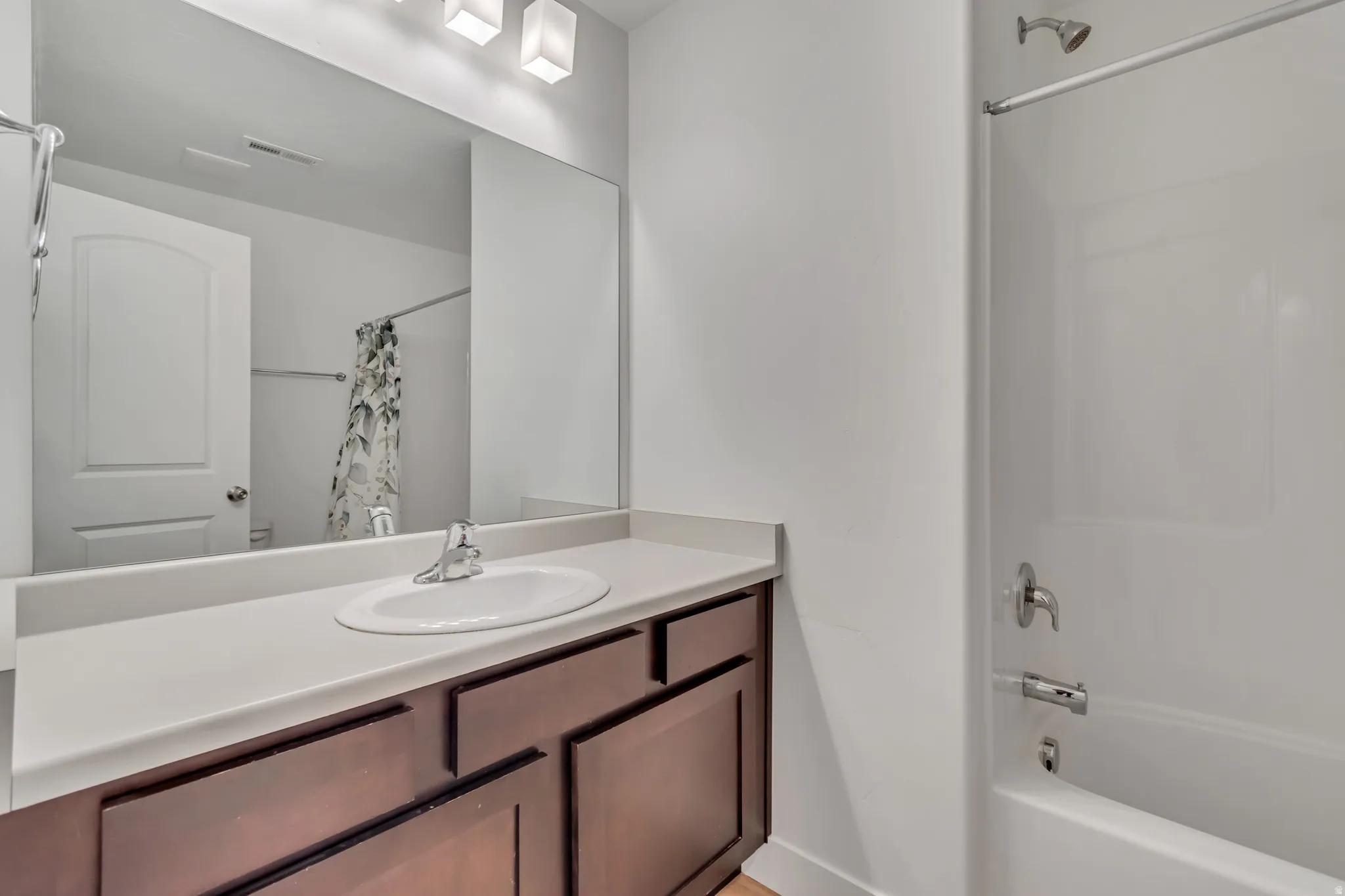 Full bathroom featuring vanity and shower / bath combination with curtain