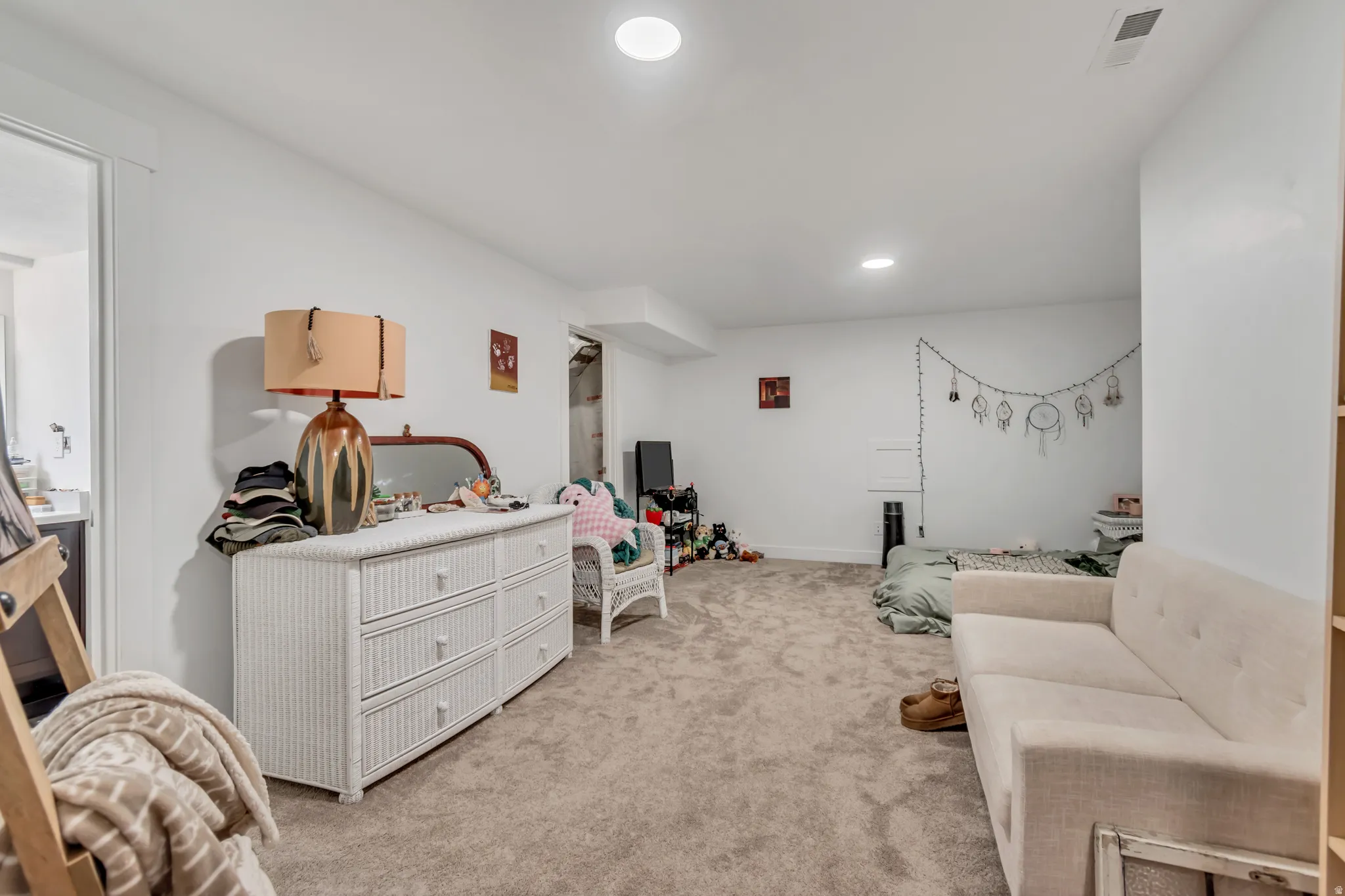 Sitting room with light colored carpet and recessed lighting