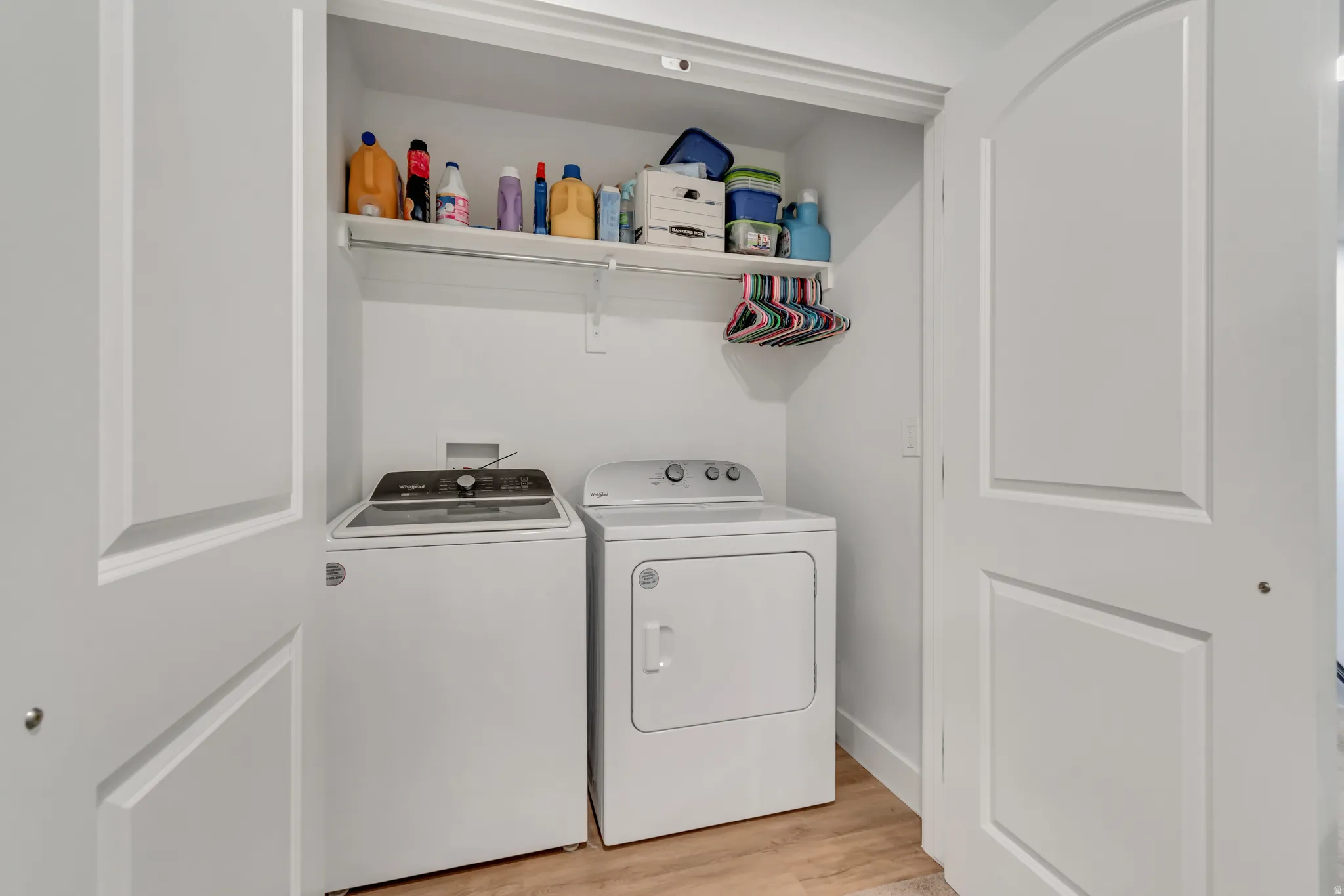 Laundry area with light wood-style floors and washer and dryer