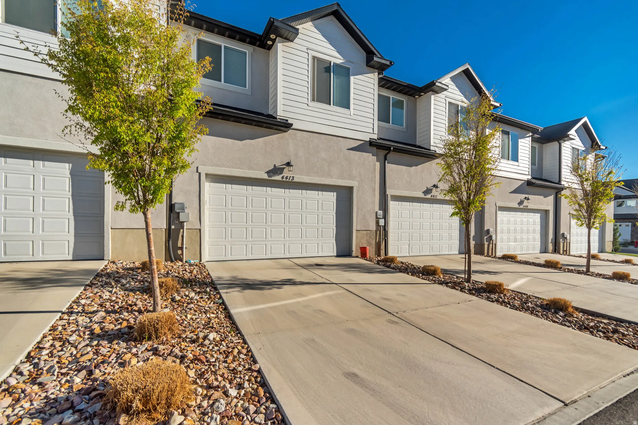 Traditional home featuring a garage, concrete driveway, and stucco siding