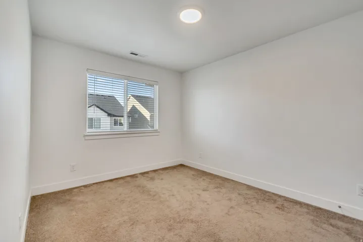 Spare room featuring carpet flooring and baseboards