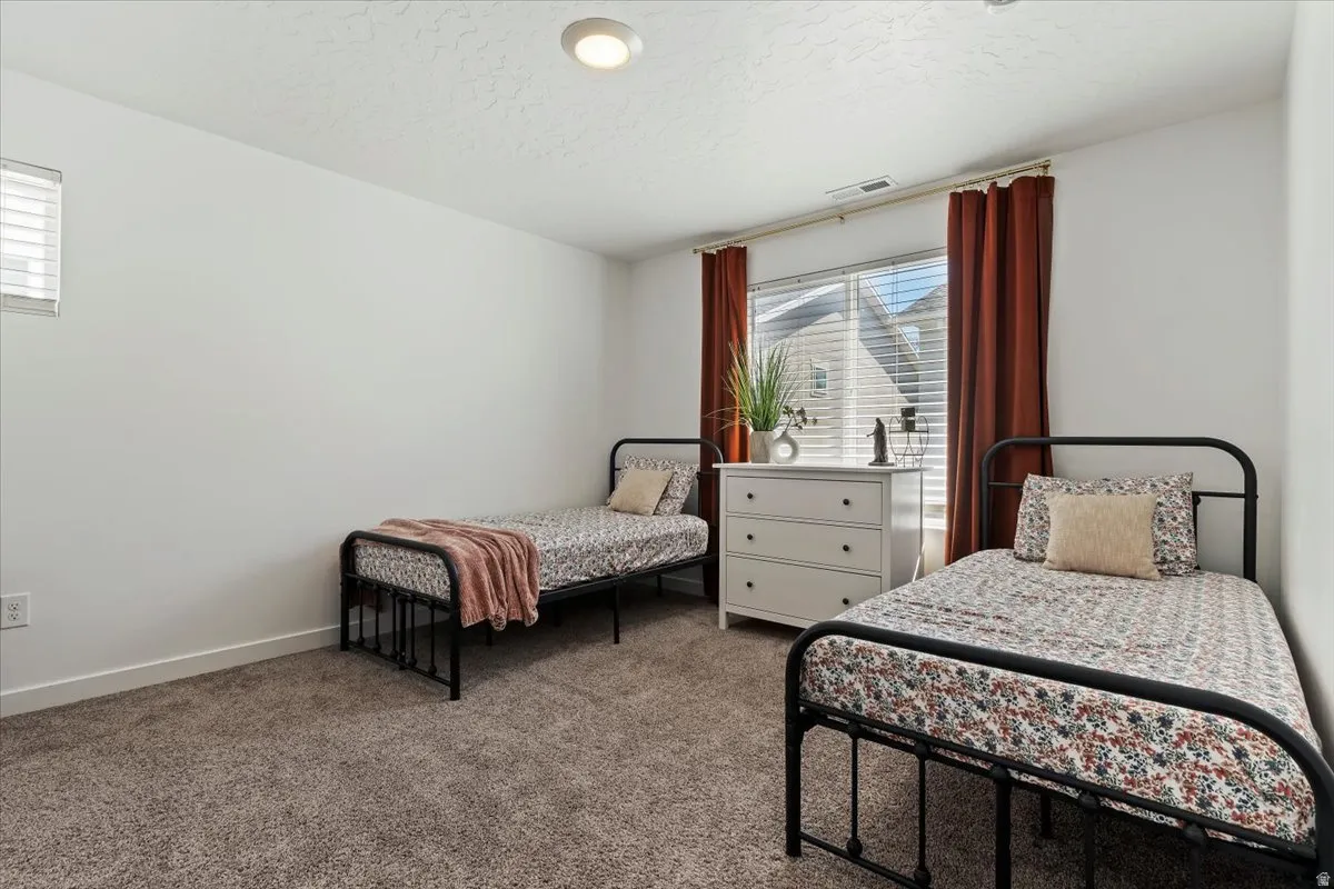 Bedroom featuring multiple windows, carpet, and a textured ceiling
