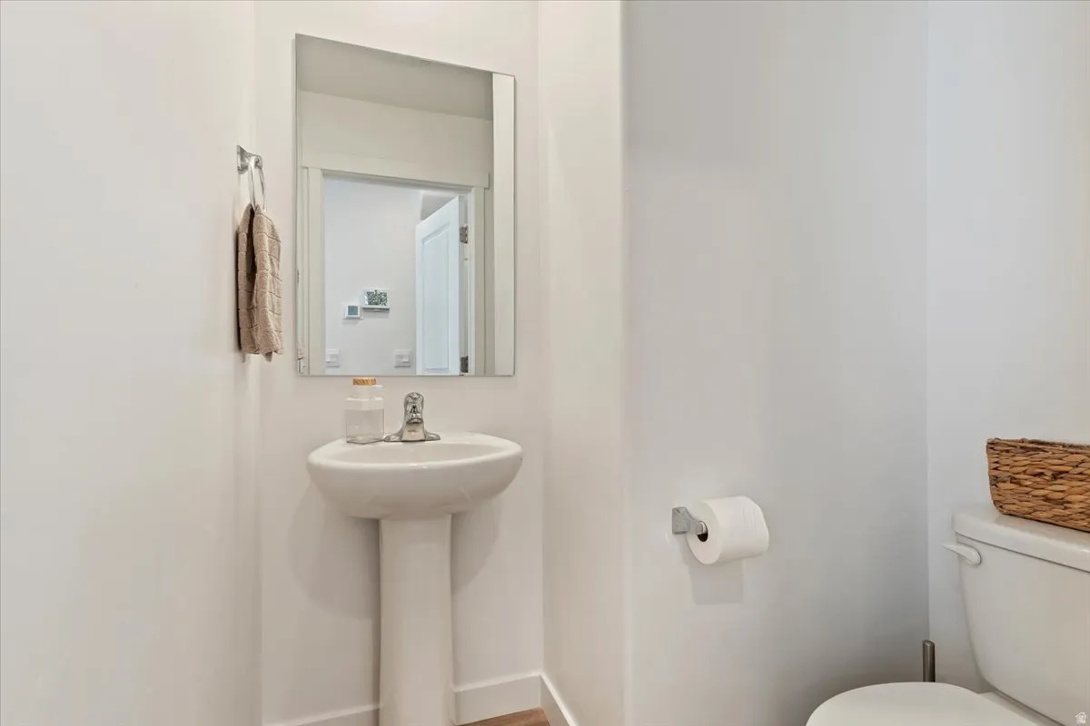 Half bathroom with toilet and baseboards