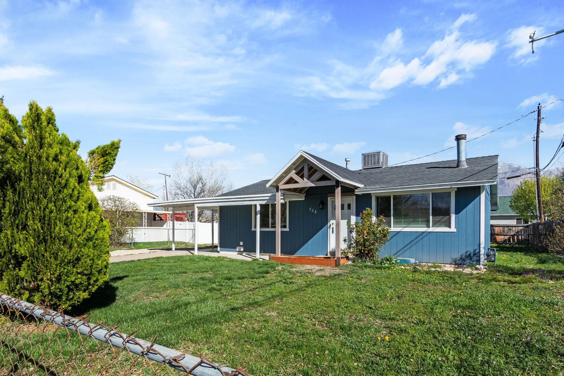 View of front of house featuring covered porch, a carport, and roof with shingles