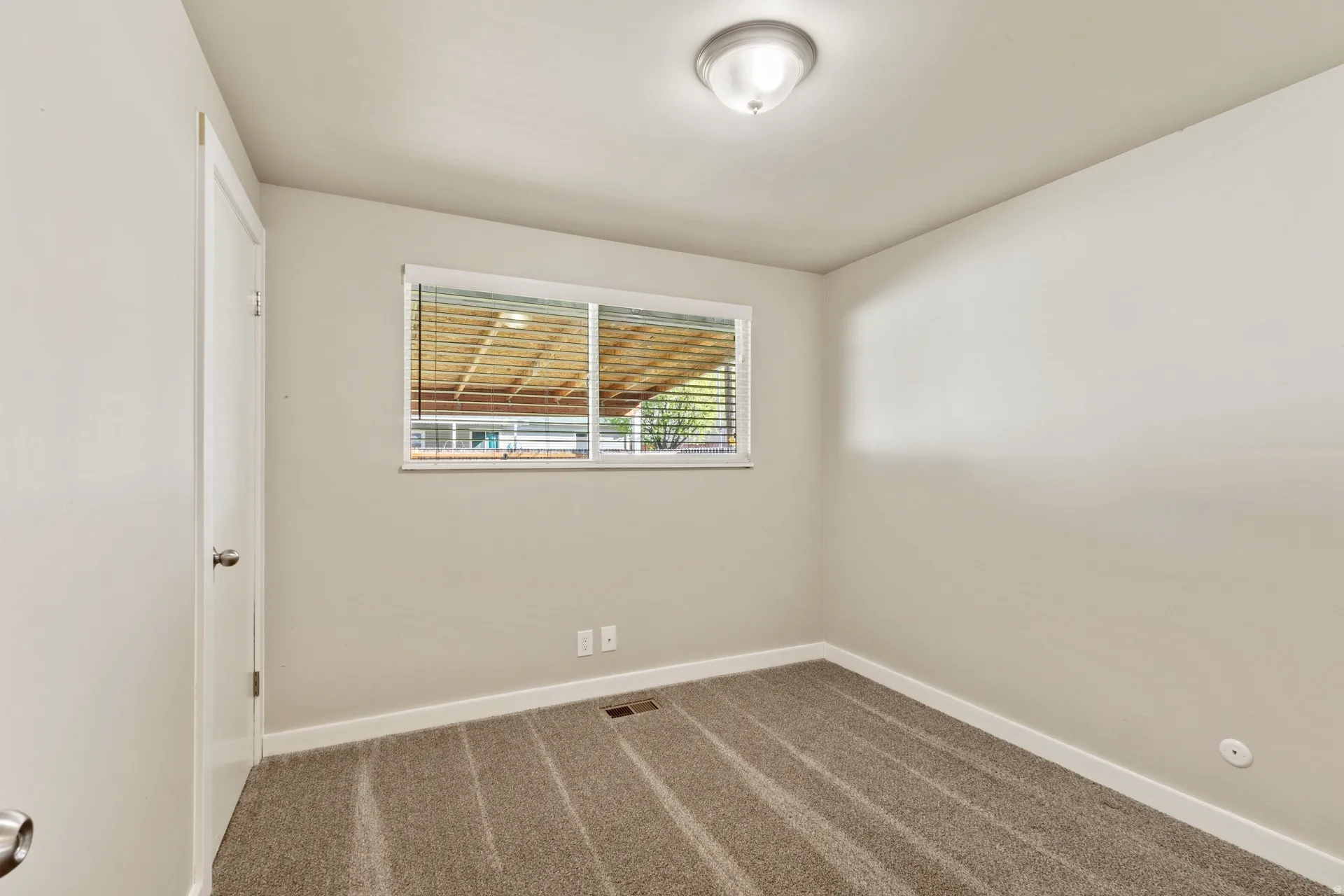 Unfurnished room with baseboards and dark carpet