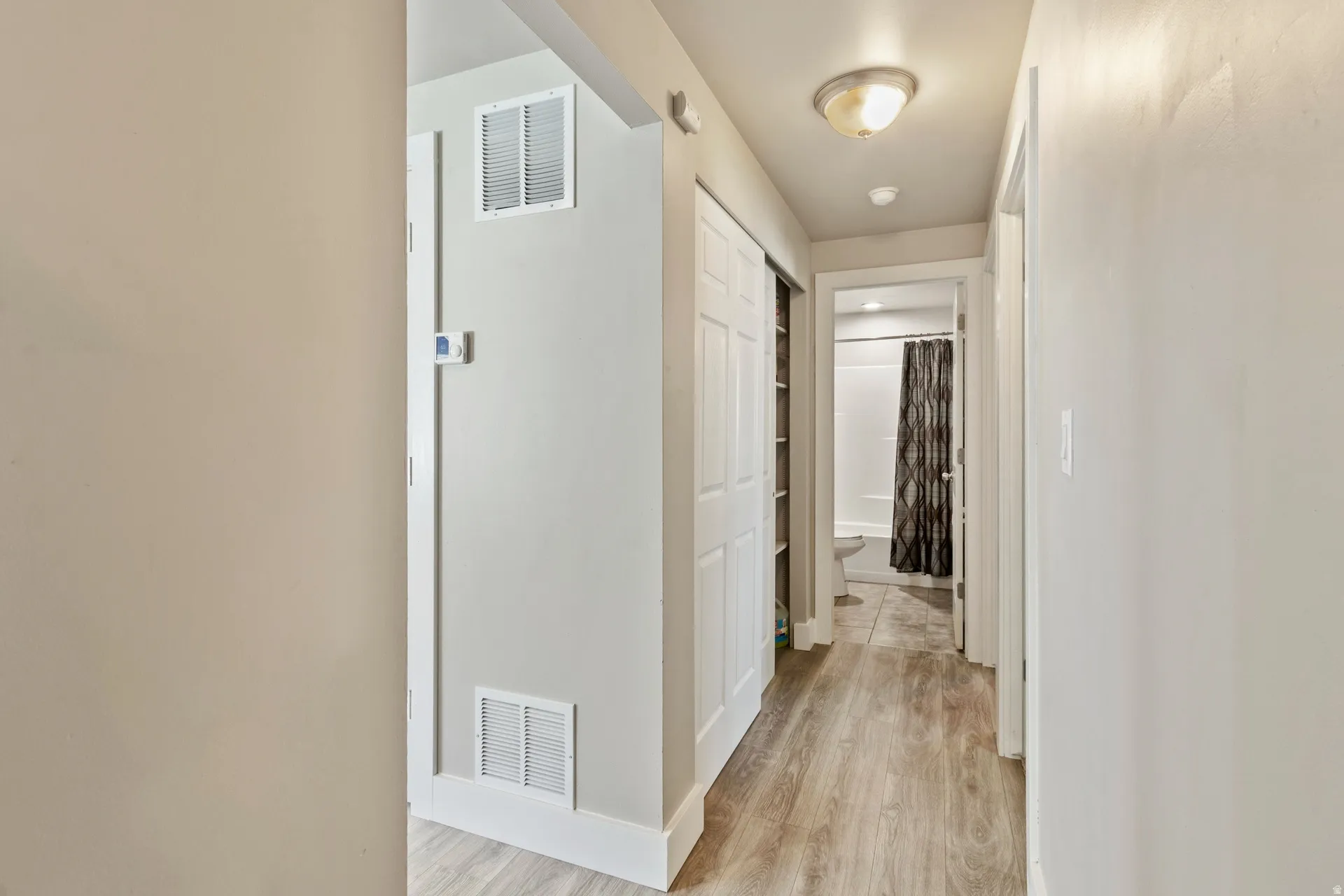 Hall with light wood finished floors and baseboards
