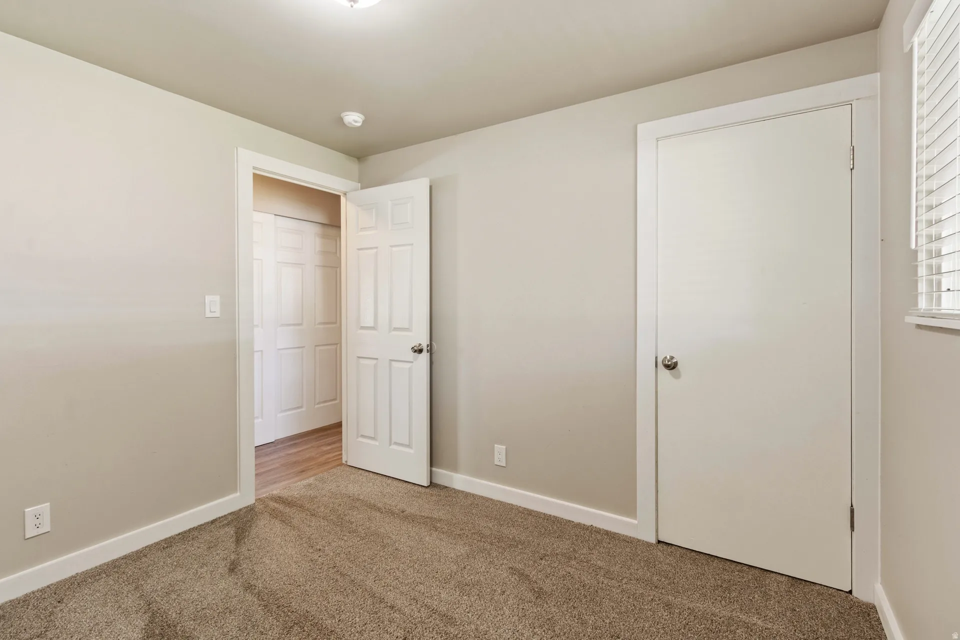 Unfurnished bedroom featuring carpet floors and baseboards