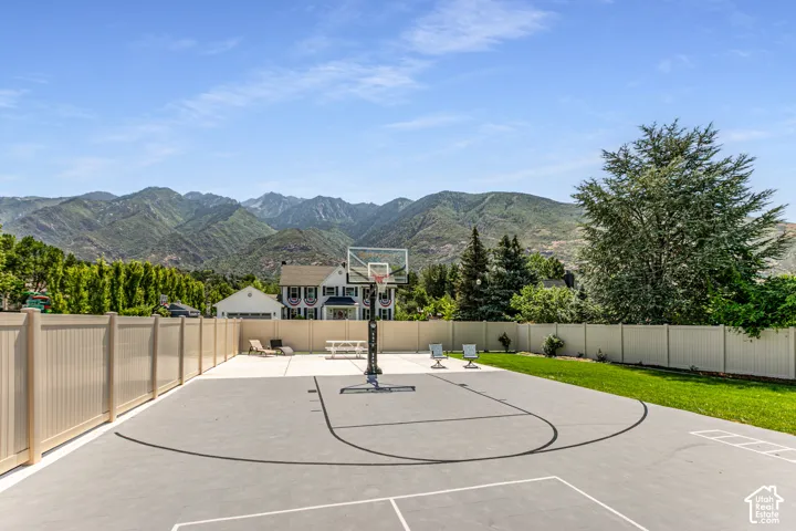 View of basketball court with a mountain view, a patio, and basketball court