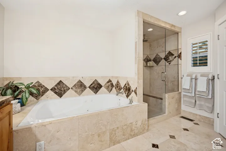 Primary ensuite with jetted tub, large shower, and recessed lighting