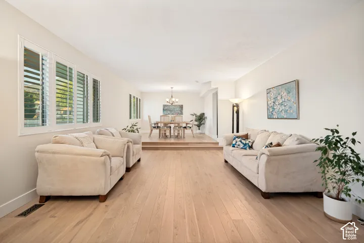 Formal Living-Dining Room with Hardwood flooring, white plantation shutters, and a raised dining area