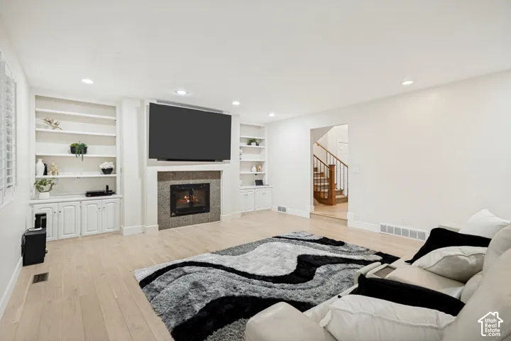 Built-in shelving and cabinetry with upgraded fireplace and hardwood flooring