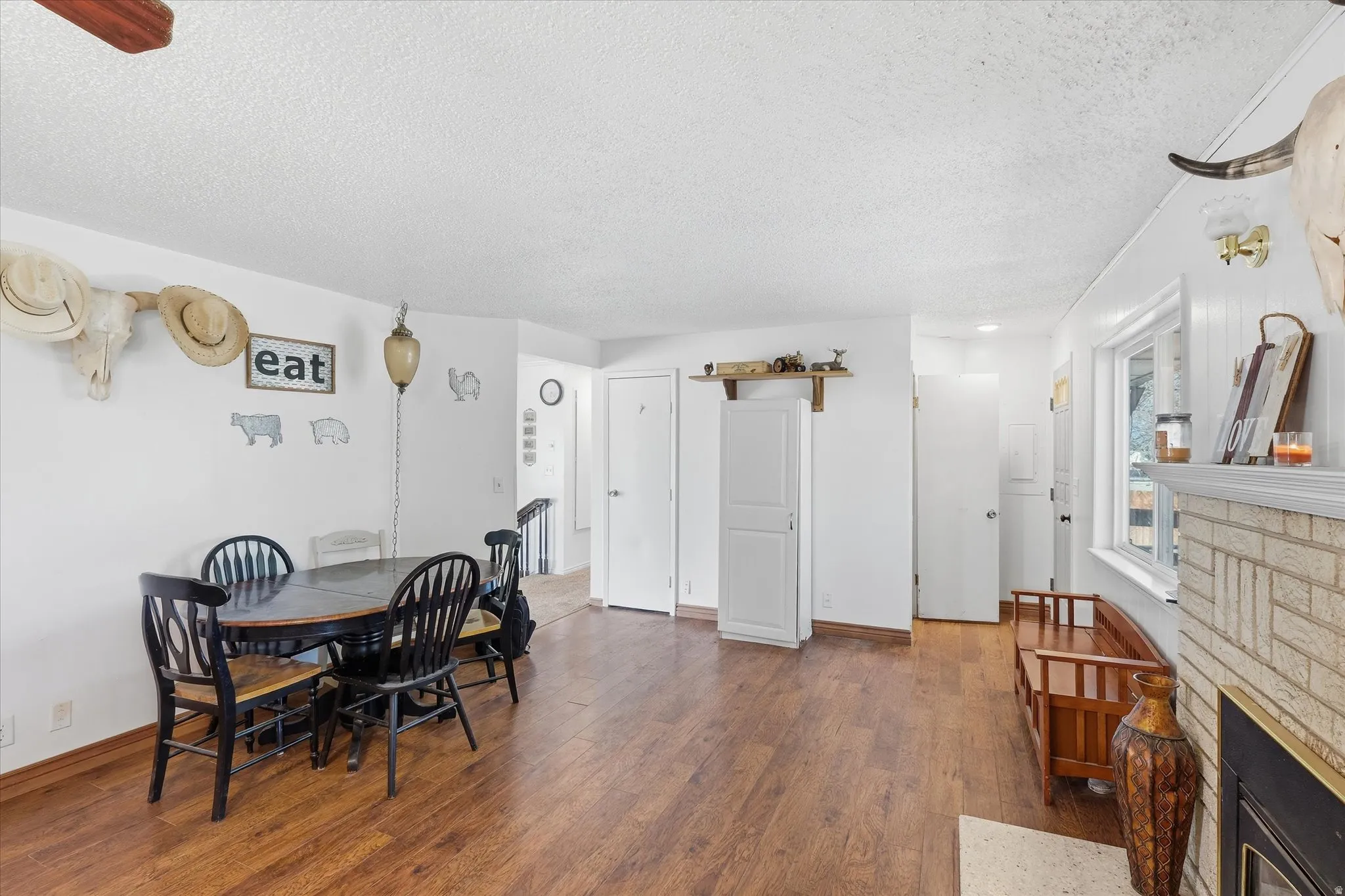 Dining room featuring a fireplace, dark wood-type flooring, and a textured ceiling