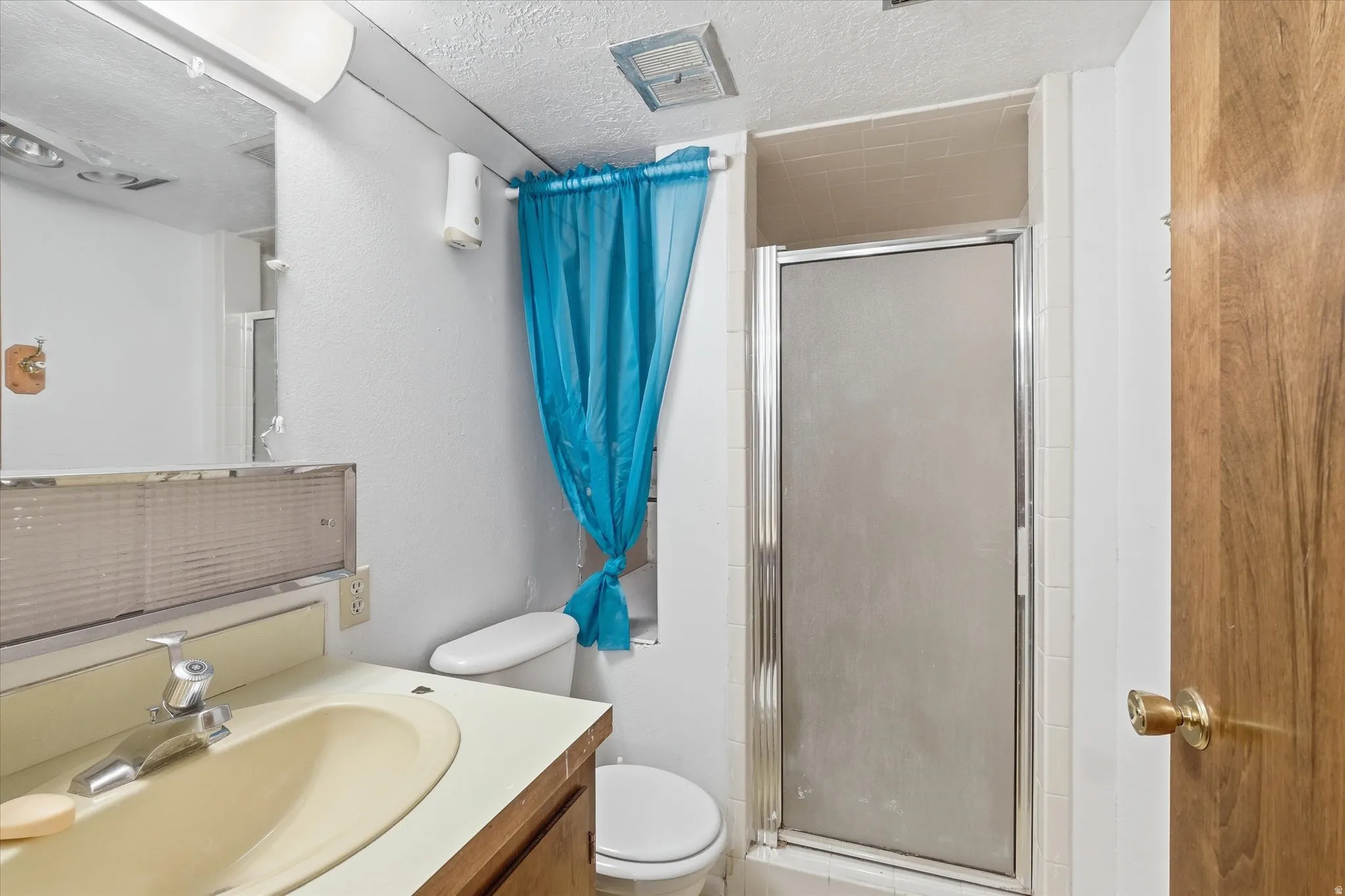 3/4 featuring vanity, a stall shower, and a textured ceiling