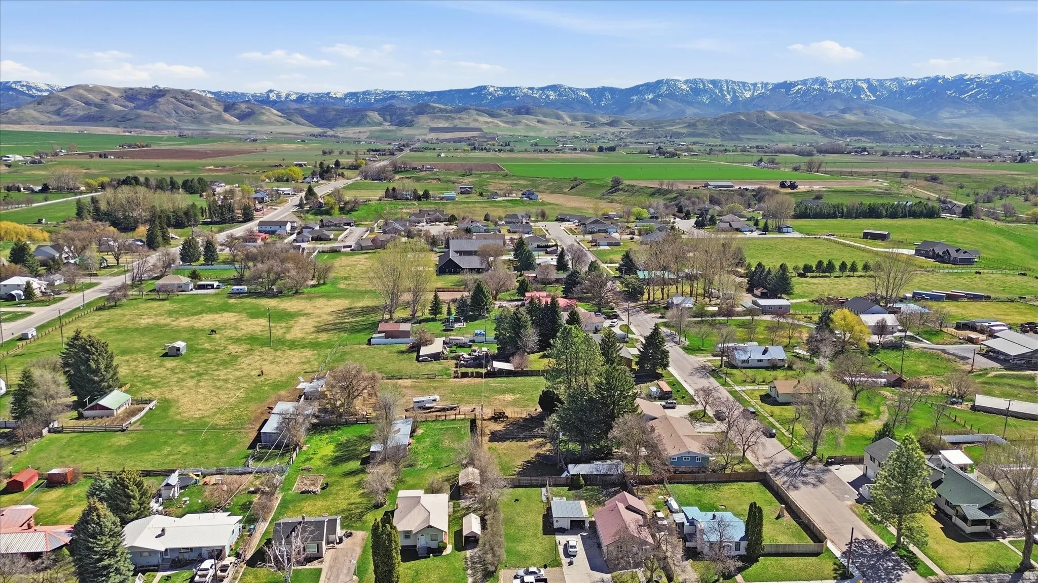 Aerial view of property and surrounding area featuring nearby suburban area and rural landscape