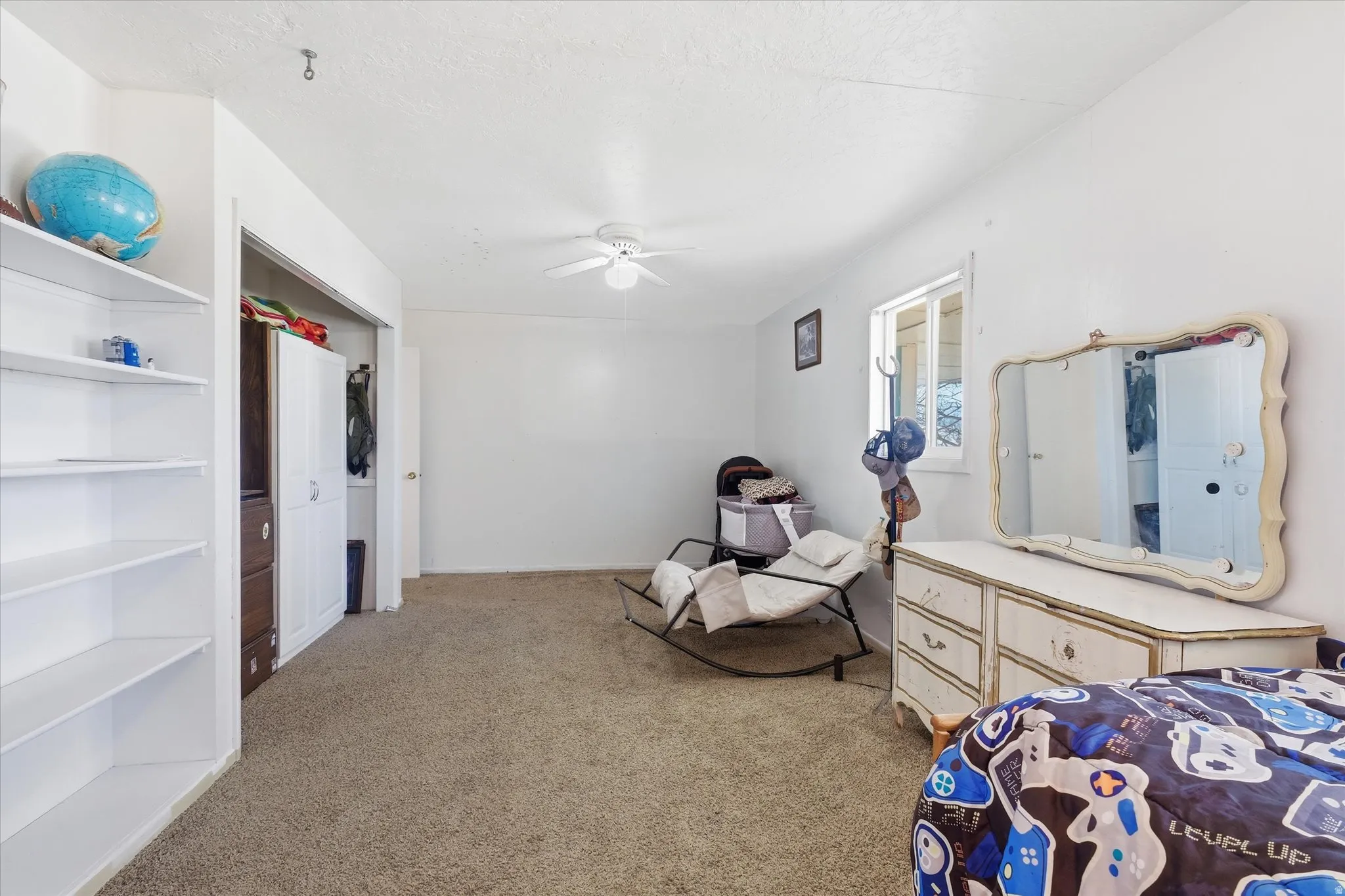 Bedroom featuring a ceiling fan, light colored carpet, and a closet