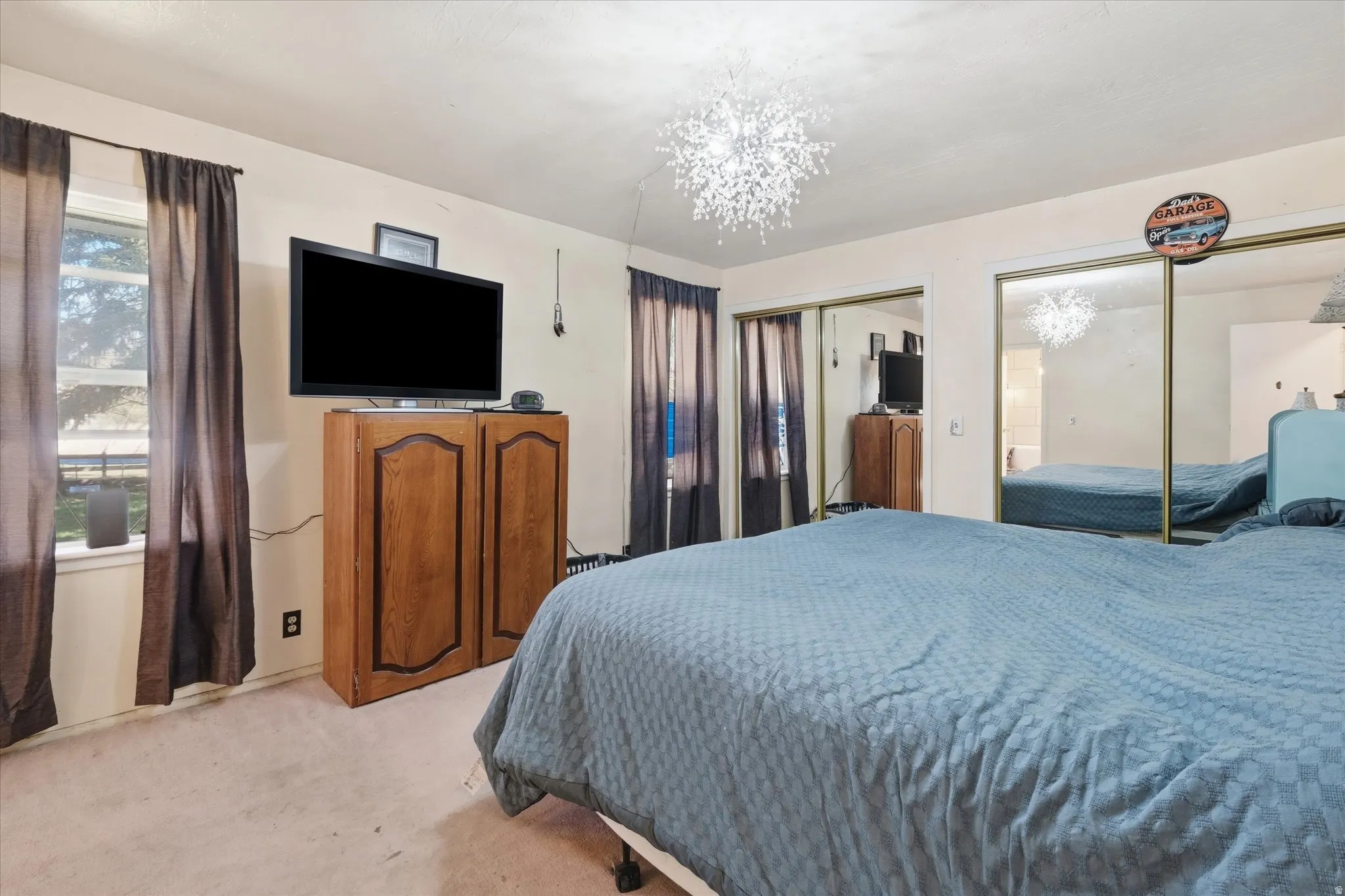 Bedroom featuring two closets, light carpet, and hanging lights
