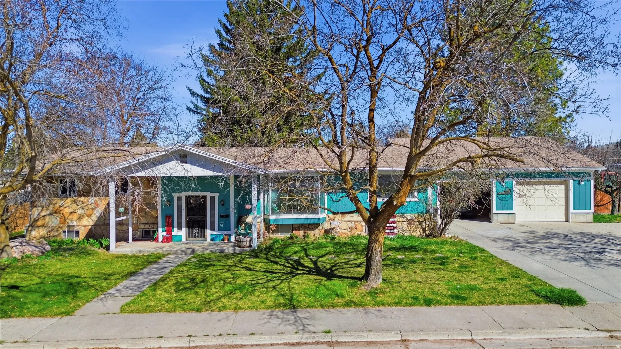 View of front of house with driveway, a front lawn, and an attached garage