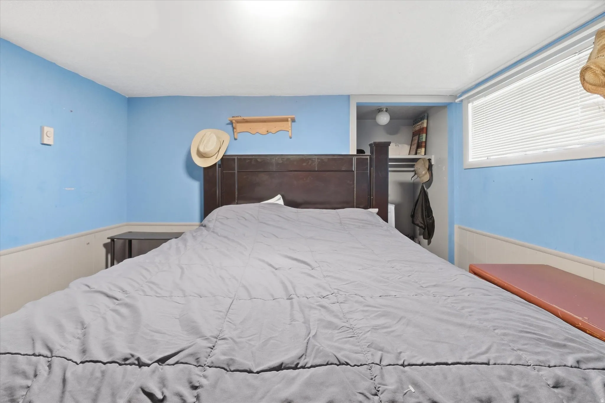 Bedroom 1 in basement featuring a wainscoted wall and wood walls