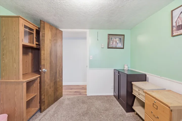 Bedroom 2 in basement with a textured ceiling and light colored carpet