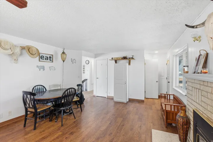Dining room featuring a fireplace, dark wood-type flooring, and a textured ceiling